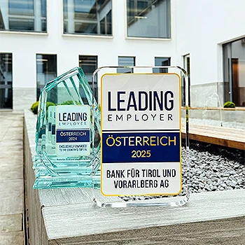 Trophäe des Leading Employer Awards Österreich 2025 für die Bank für Tirol und Vorarlberg AG, im Hintergrund mehrere weitere Awards der BTV