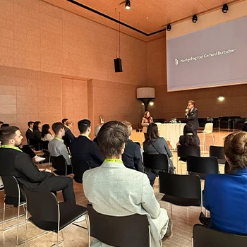 Gerhard Burtscher hält eine Präsentation vor Mitarbeiterinnen und Mitarbeitern der BTV. Auf der Präsentationsfolie ist zu lesen: "Nachgefragt bei Gerhard Burtscher"